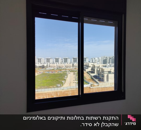 חלון אלומיניום עם נוף עירוני ברקע